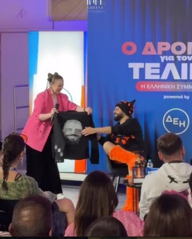 Akylas receiving his hand-painted portrait jacket on stage