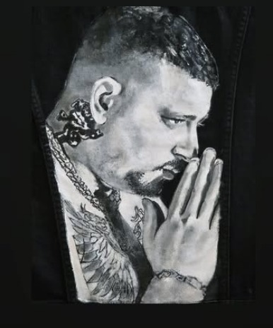 Hand-painted portrait of a praying man on black denim